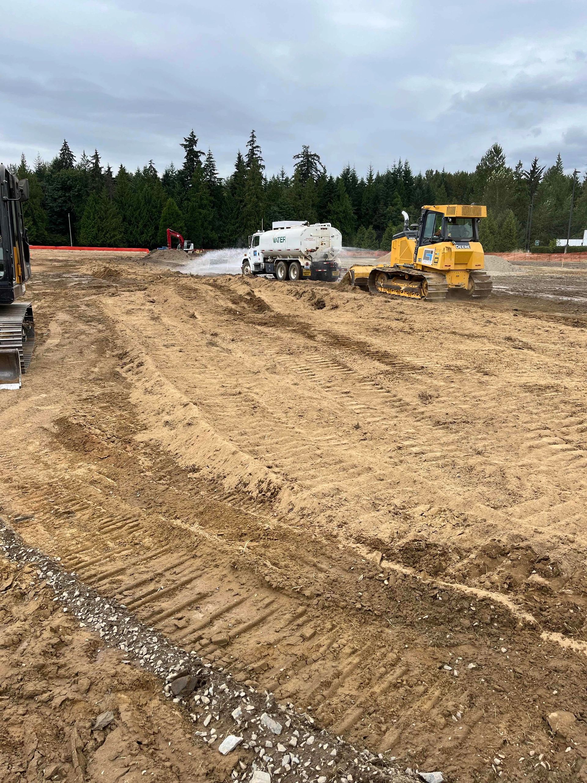 Volvo bulldozer and water truck on construction site