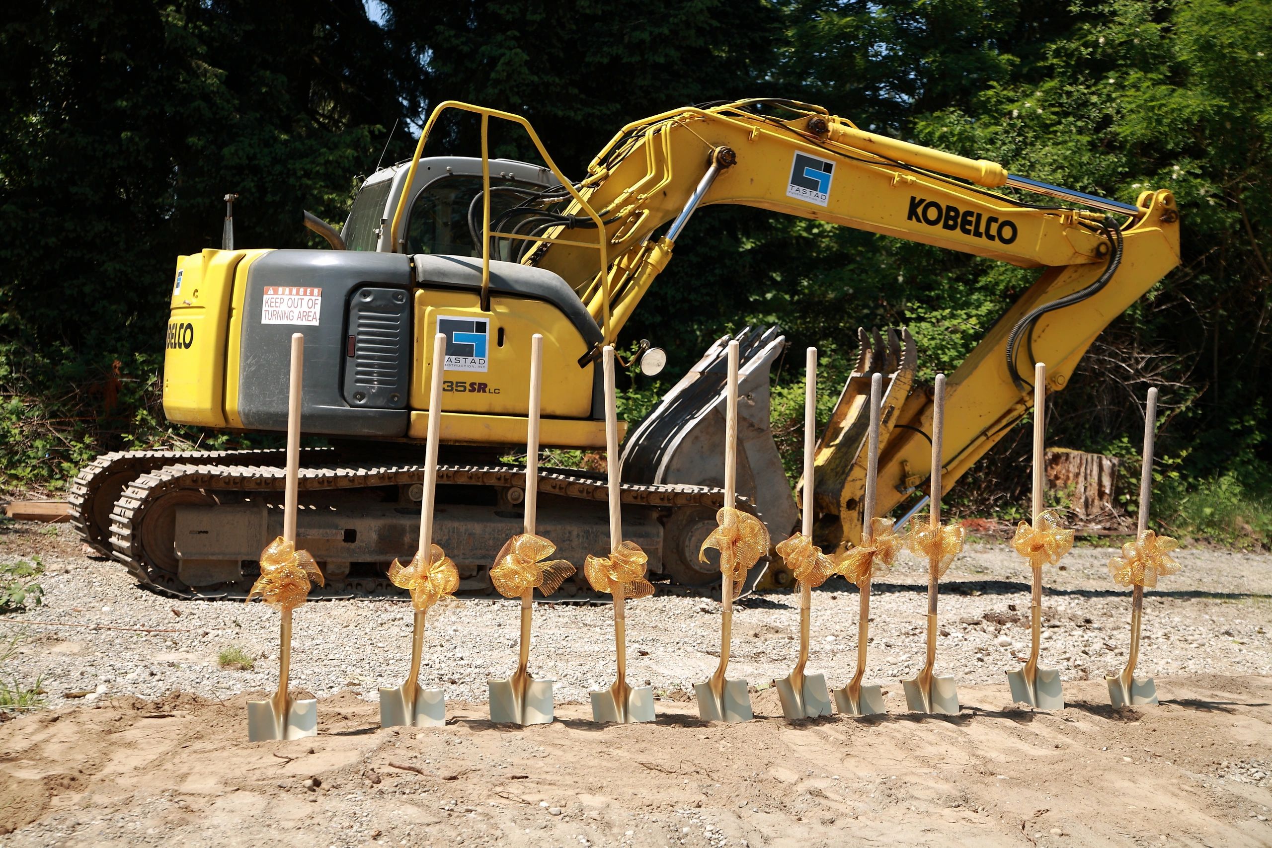 Groundbreaking ceremony with Kobelco excavator and golden shovels